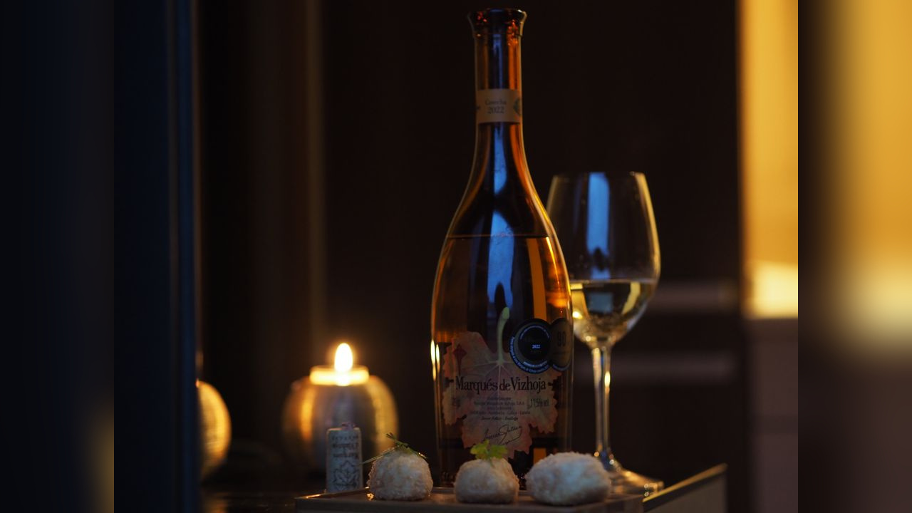 Marqués de Vizhoja junto a una copa, una vela y aperitivos