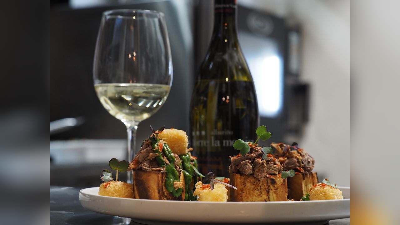 Plato acompañado de Torre la Moreira y una copa de vino blanco